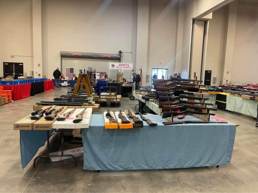 gun show vendor tables displaying shotguns for sale