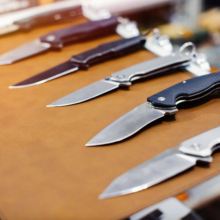 a display of pocket knives on a brown table