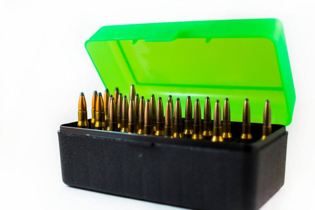 Black and green plastic ammunition box filled with rifle ammo