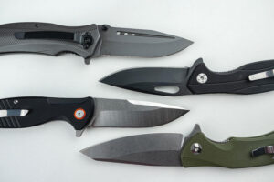 four different tactical knives placed next to each other on a white background