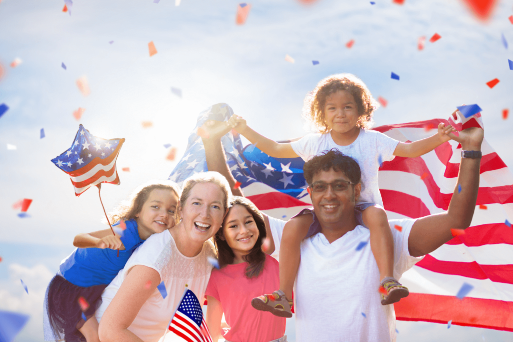patriotic family posing together with american flag and patriotic balloons