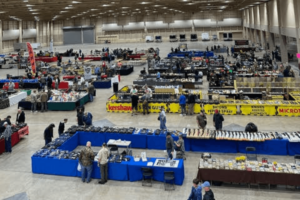 customers browsing vendor tables at an indoor mac shows event