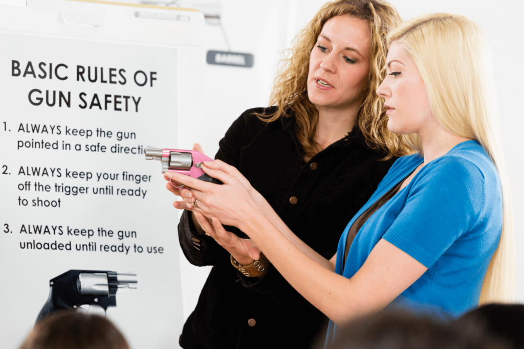 woman teaching another woman about the basic rules of gun safety
