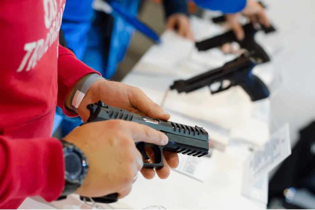 A man holding a gun at a gun show display