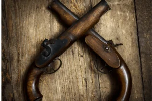Two old vintage guns on a wooden table