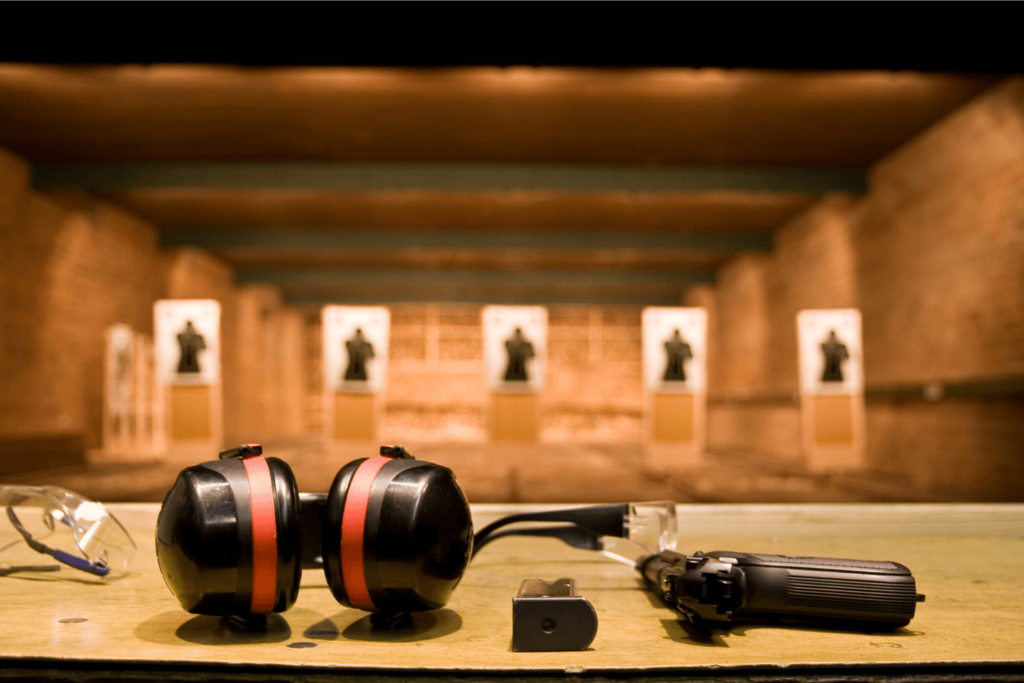 Inside of a shooting range with targets, gun, and personal protection equipment