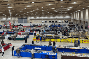 Large building with various gun show vendor tables set up for a MAC Shows event
