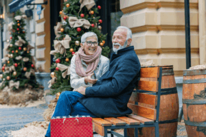Couple sitting on a bench outside with their shopping bags during Christmas time
