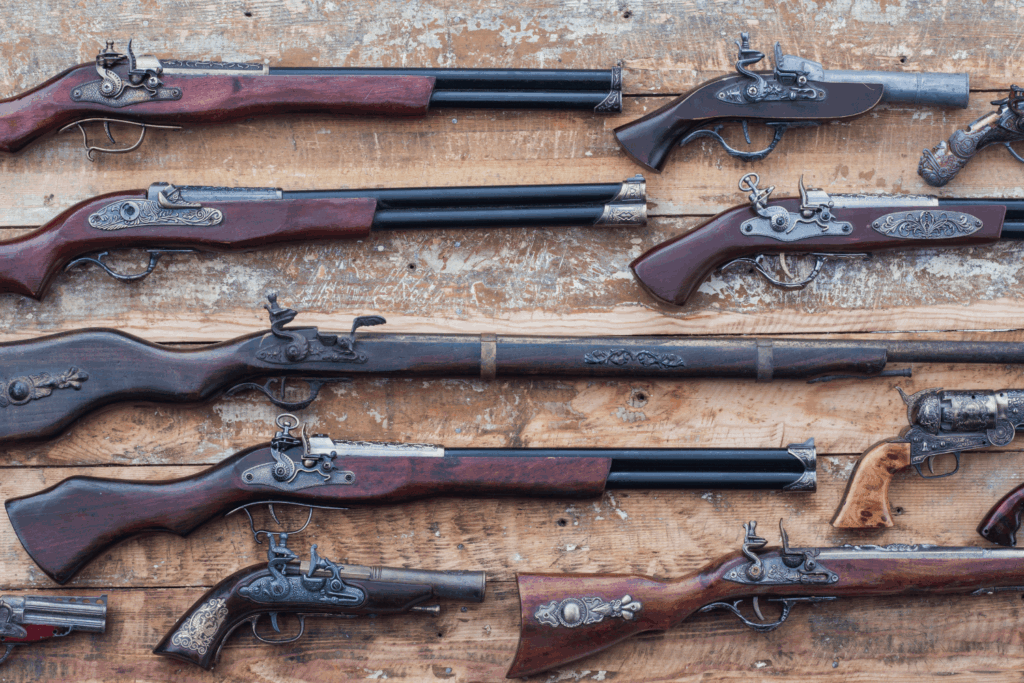 Various historical weapons are laying next to each other on a table