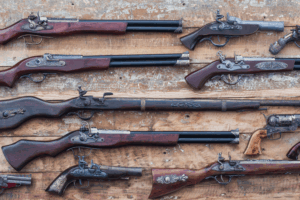 Various historical weapons are laying next to each other on a table