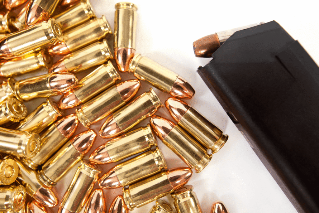 pile of ammunition next to a filled magazine
