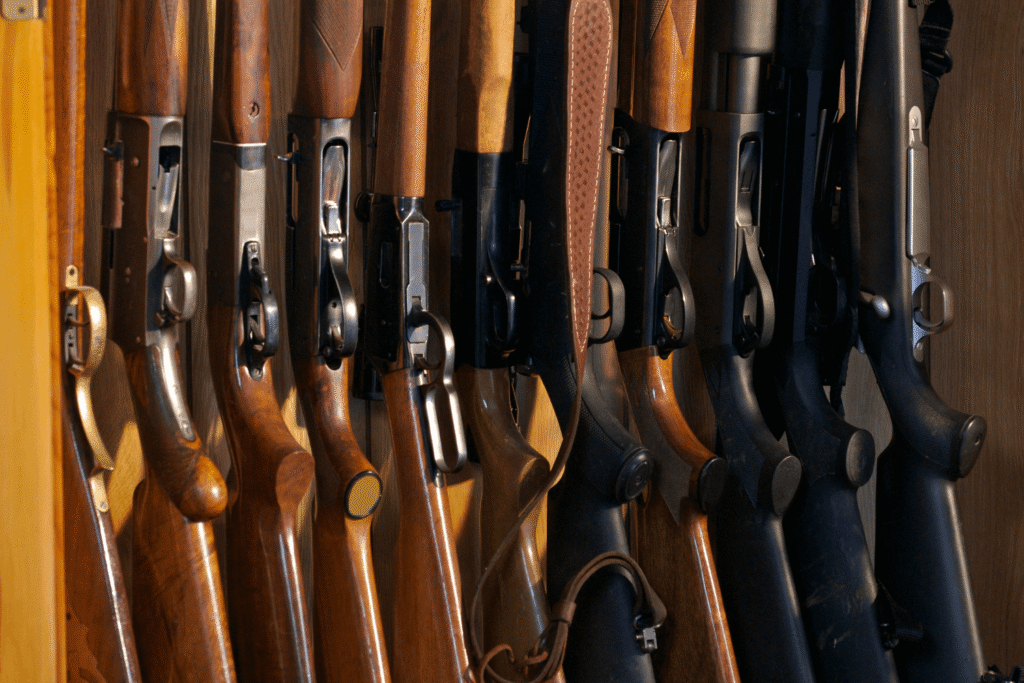 multiple rifles stored on a wooden rack