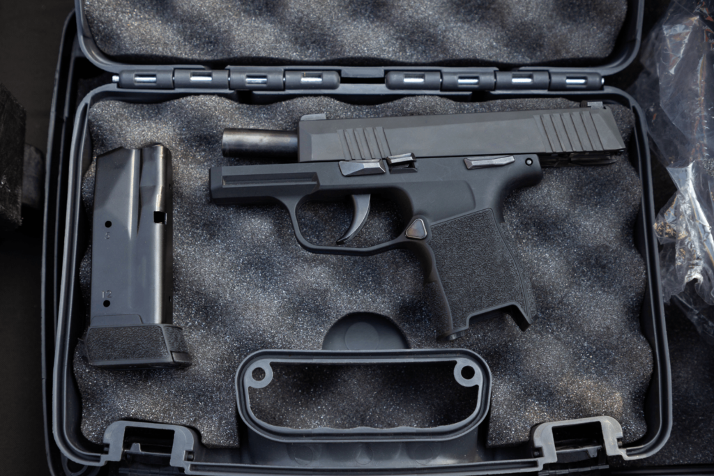 black pistol and magazine in a black gun case