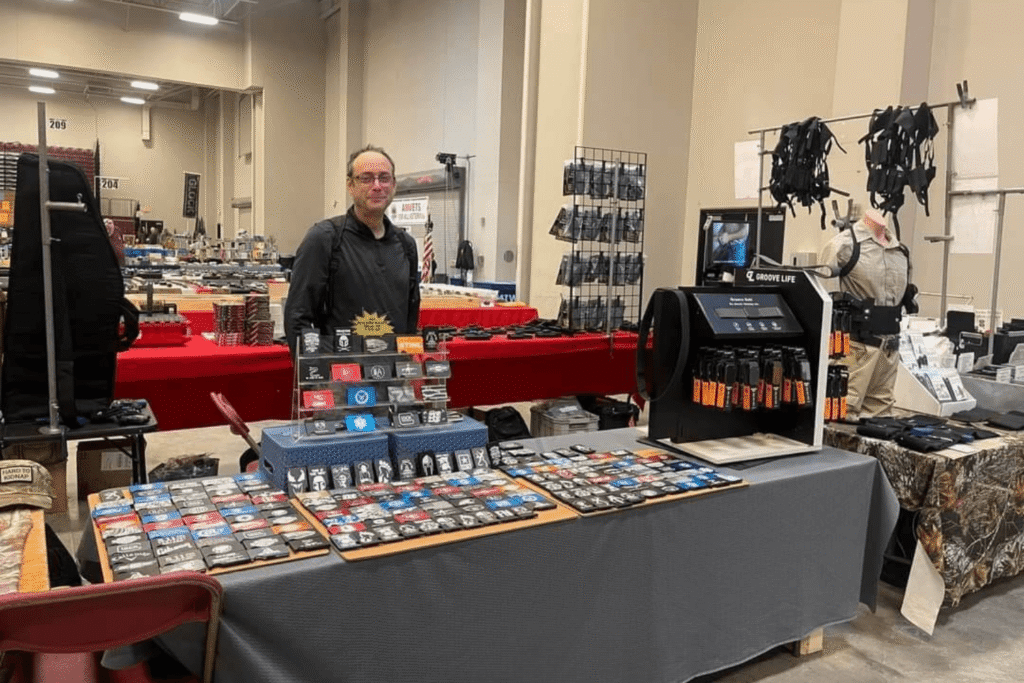 vendor standing behind his table at a gun show