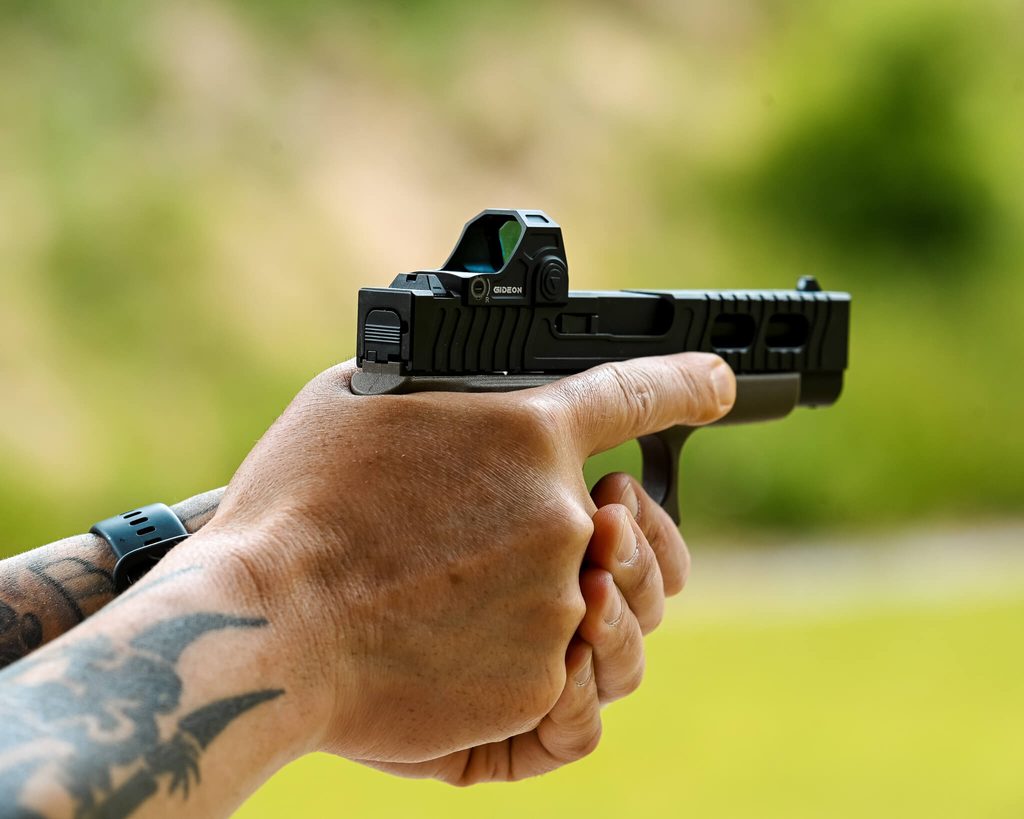 Close up of a man aiming a pistol to represent firearm grip